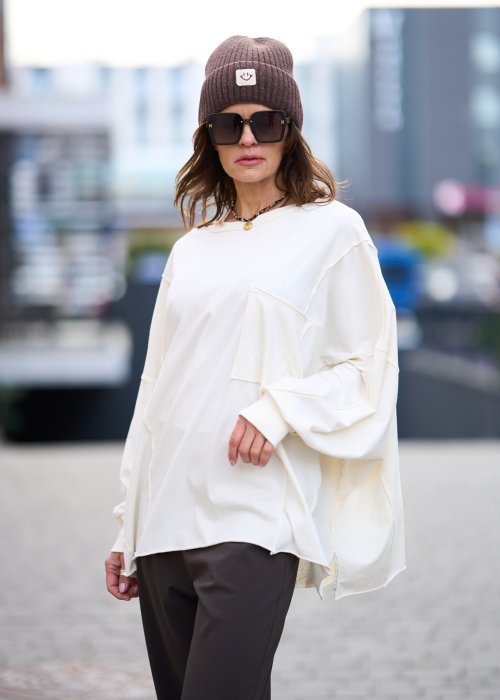 Biała bluzka damska oversize z dużą kieszenią z przodu i obniżoną linią ramion
