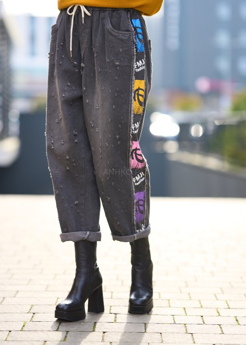 Ciemnoszare jeansowe spodnie z kolorowymi naszywkami i przetarciami, luźny fason z wiązaniem w pasie