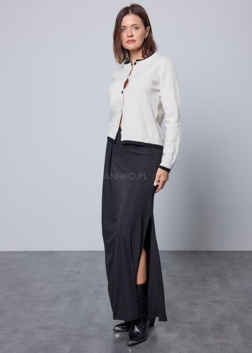 Jasnobeżowy kardigan zapinany na czarne guziki, z czarnymi lamówkami przy kołnierzu, mankietach i dole