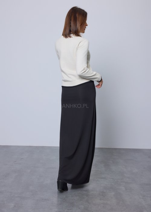 Jasnobeżowy kardigan zapinany na czarne guziki, z czarnymi lamówkami przy kołnierzu, mankietach i dole