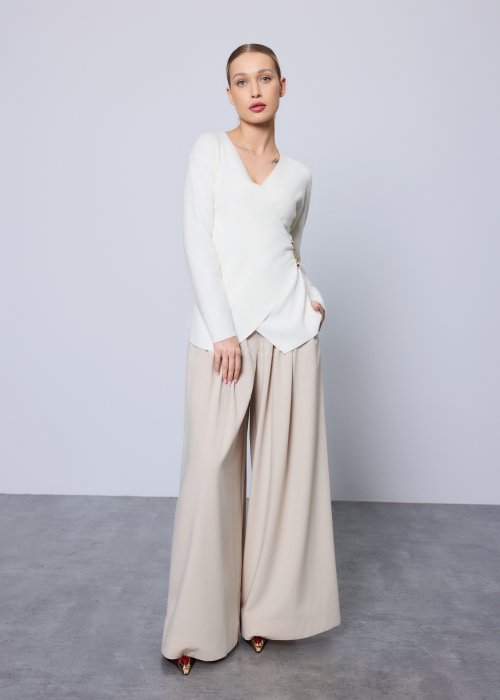 Beżowe spodnie damskie wide leg z wysokim stanem i szerokimi nogawkami, elegancki, lejący fason w nowoczesnej stylizacji.