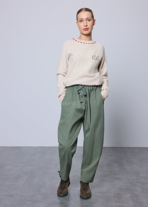 Kremowy, miękki sweter z czerwonymi przeszyciami i świątecznym haftem choinek