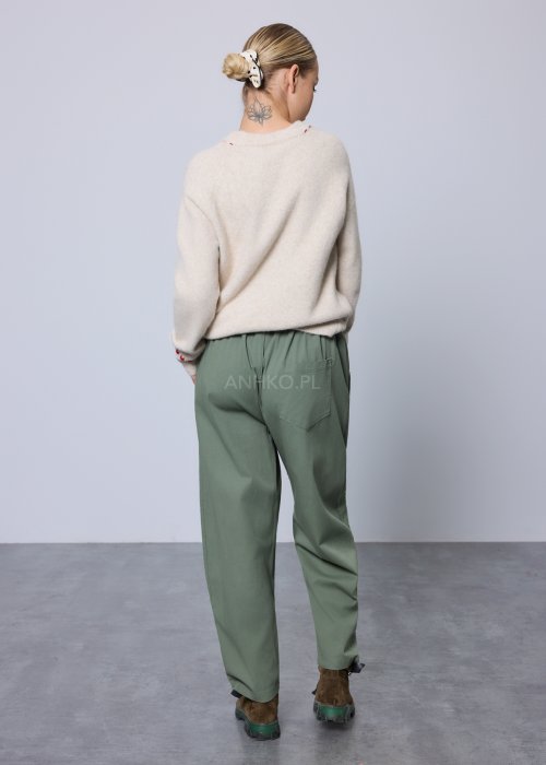 Kremowy, miękki sweter z czerwonymi przeszyciami i świątecznym haftem choinek