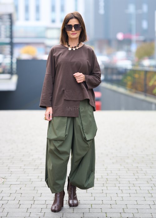 Zielone spodnie o szerokich nogawkach z dużymi kieszeniami cargo z przodu, zakończone zwężanym dołem