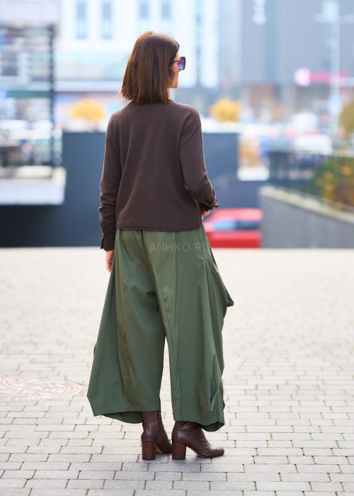 Zielone spodnie o szerokich nogawkach z dużymi kieszeniami cargo z przodu, zakończone zwężanym dołem