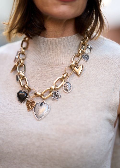 Złoty naszyjnik z dużymi ogniwami i zawieszkami w kształcie serc oraz medalionów. Efektowna biżuteria damska podkreślająca szyję i uzupełniająca elegancką stylizację.