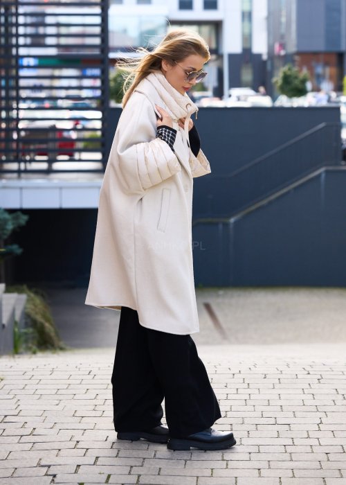 Elegancki płaszcz damski w kolorze ecru z pikowanymi rękawami, długim krojem i klasycznym kołnierzem oversize