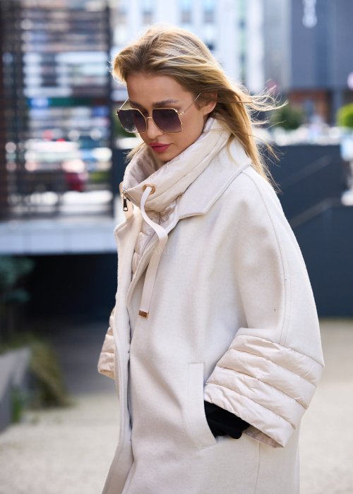 Elegancki płaszcz damski w kolorze ecru z pikowanymi rękawami, długim krojem i klasycznym kołnierzem oversize