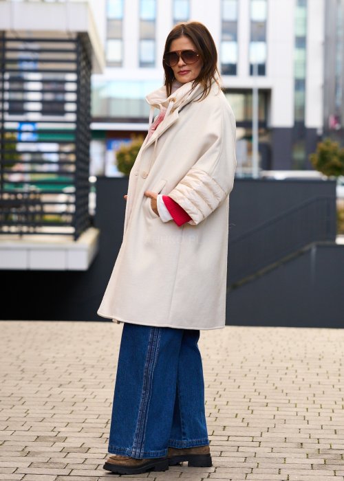 Elegancki płaszcz damski w kolorze ecru z pikowanymi rękawami, długim krojem i klasycznym kołnierzem oversize