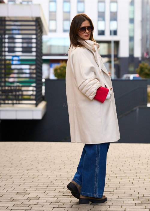 Elegancki płaszcz damski w kolorze ecru z pikowanymi rękawami, długim krojem i klasycznym kołnierzem oversize