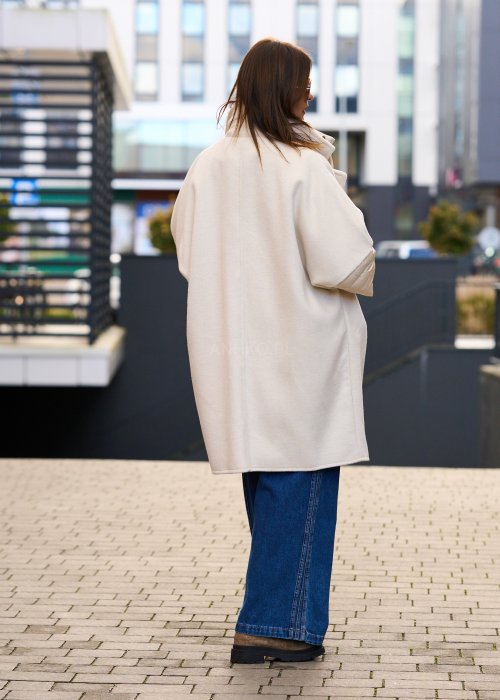 Elegancki płaszcz damski w kolorze ecru z pikowanymi rękawami, długim krojem i klasycznym kołnierzem oversize