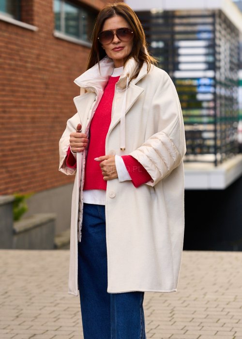 Elegancki płaszcz damski w kolorze ecru z pikowanymi rękawami, długim krojem i klasycznym kołnierzem oversize