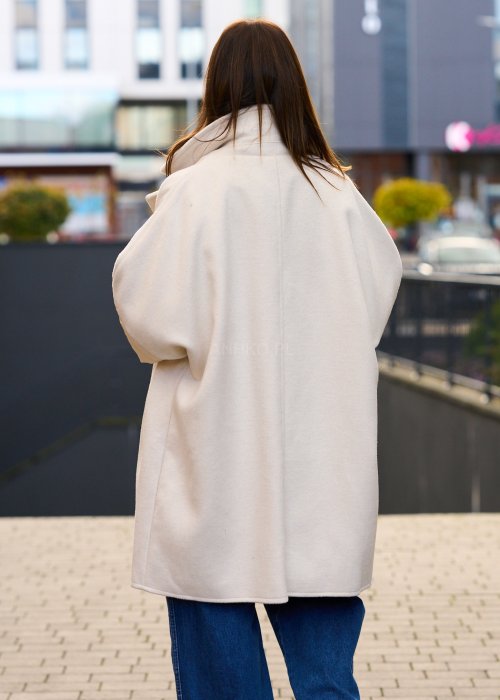 Elegancki płaszcz damski w kolorze ecru z pikowanymi rękawami, długim krojem i klasycznym kołnierzem oversize