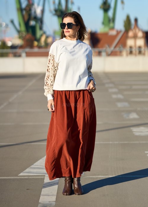 Ceglana spódnica maxi z elastyczną talią i kieszeniami, o luźnym kroju, zestawiona z brązową marynarką i skórzanymi botkami na obcasie w eleganckiej, miejskiej stylizacji.