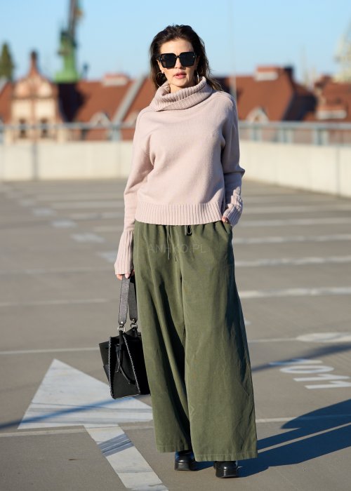 Sztruksowe spodnie damskie w kolorze khaki z szeroką nogawką i elastycznym pasem, zestawione z oversize’owym swetrem i botkami na obcasie.