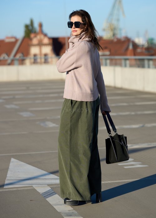 Sztruksowe spodnie damskie w kolorze khaki z szeroką nogawką i elastycznym pasem, zestawione z oversize’owym swetrem i botkami na obcasie.