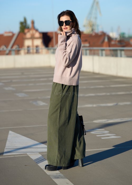 Sztruksowe spodnie damskie w kolorze khaki z szeroką nogawką i elastycznym pasem, zestawione z oversize’owym swetrem i botkami na obcasie.
