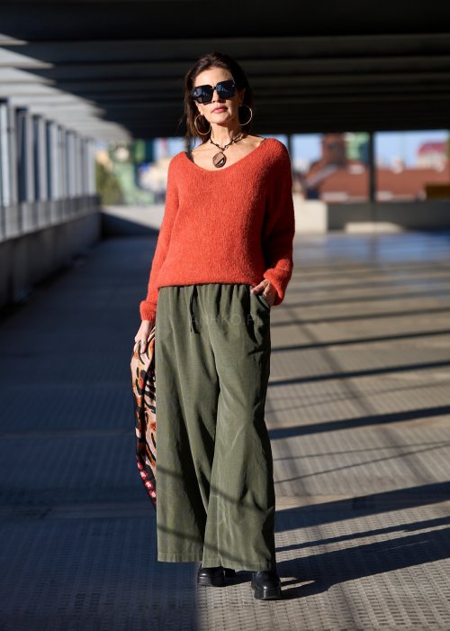 Sztruksowe spodnie damskie w kolorze khaki z szeroką nogawką i elastycznym pasem, zestawione z oversize’owym swetrem i botkami na obcasie.