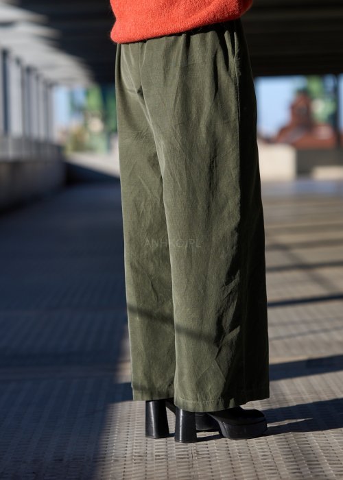 Sztruksowe spodnie damskie w kolorze khaki z szeroką nogawką i elastycznym pasem, zestawione z oversize’owym swetrem i botkami na obcasie.