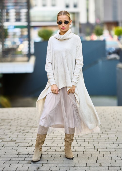 dwuczęściowa sukienka damska w kolorze kremowym, złożona z długiej, asymetrycznej tuniki z golfem i plisowanej spódnicy z tiulu