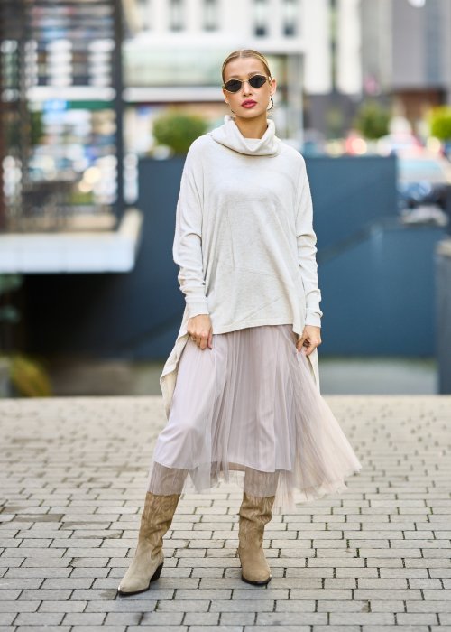 dwuczęściowa sukienka damska w kolorze kremowym, złożona z długiej, asymetrycznej tuniki z golfem i plisowanej spódnicy z tiulu