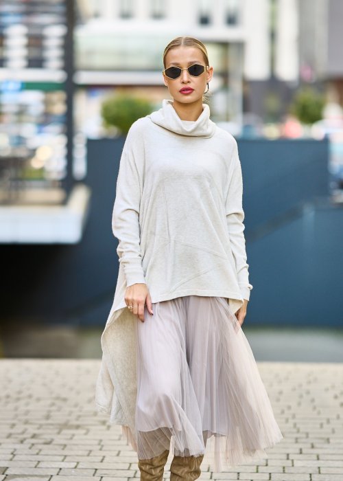 dwuczęściowa sukienka damska w kolorze kremowym, złożona z długiej, asymetrycznej tuniki z golfem i plisowanej spódnicy z tiulu