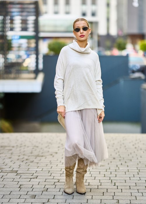 dwuczęściowa sukienka damska w kolorze kremowym, złożona z długiej, asymetrycznej tuniki z golfem i plisowanej spódnicy z tiulu