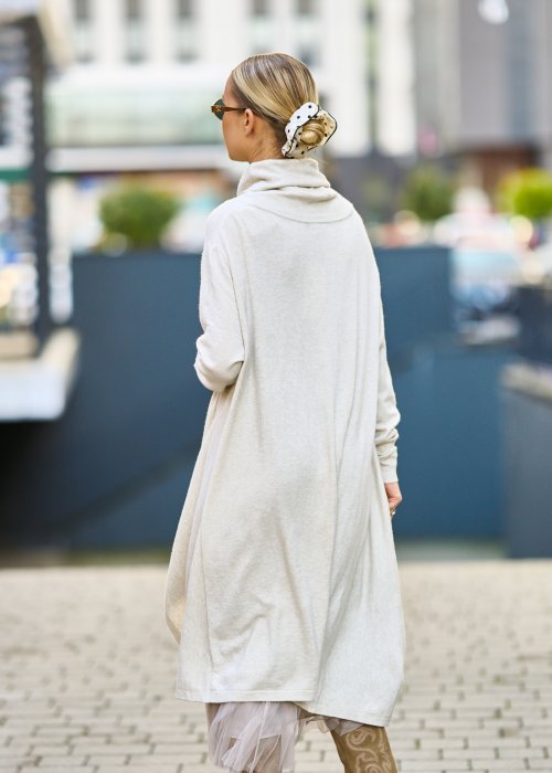 dwuczęściowa sukienka damska w kolorze kremowym, złożona z długiej, asymetrycznej tuniki z golfem i plisowanej spódnicy z tiulu