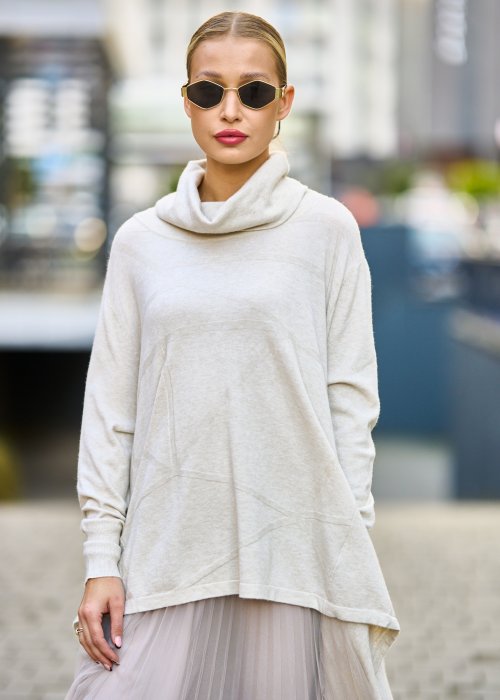 dwuczęściowa sukienka damska w kolorze kremowym, złożona z długiej, asymetrycznej tuniki z golfem i plisowanej spódnicy z tiulu