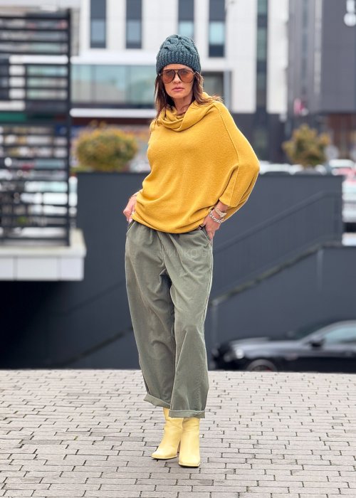 Sweter oversize w kolorze musztardowym z szerokim kołnierzem typu komin i luźnym krojem poncza. Model w stylizacji miejskiej, podkreślający miękką dzianinę i swobodny fason.