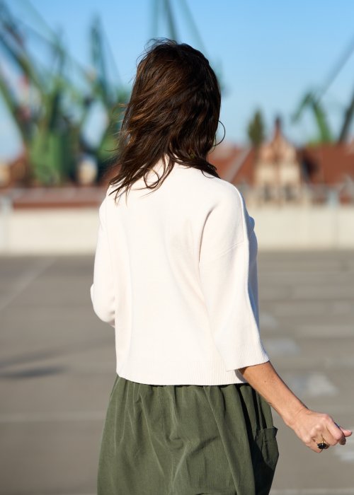 Ecru sweter damski z półgolfem i rękawem 3/4, wykonany z miękkiej dzianiny o klasycznym kroju w minimalistycznym stylu