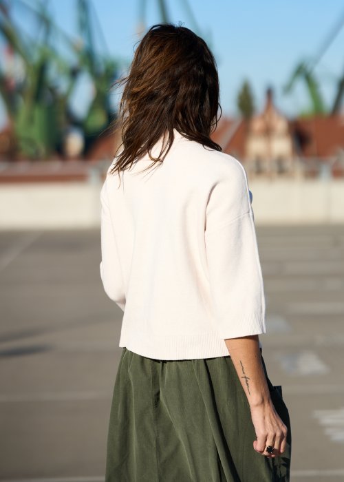 Ecru sweter damski z półgolfem i rękawem 3/4, wykonany z miękkiej dzianiny o klasycznym kroju w minimalistycznym stylu