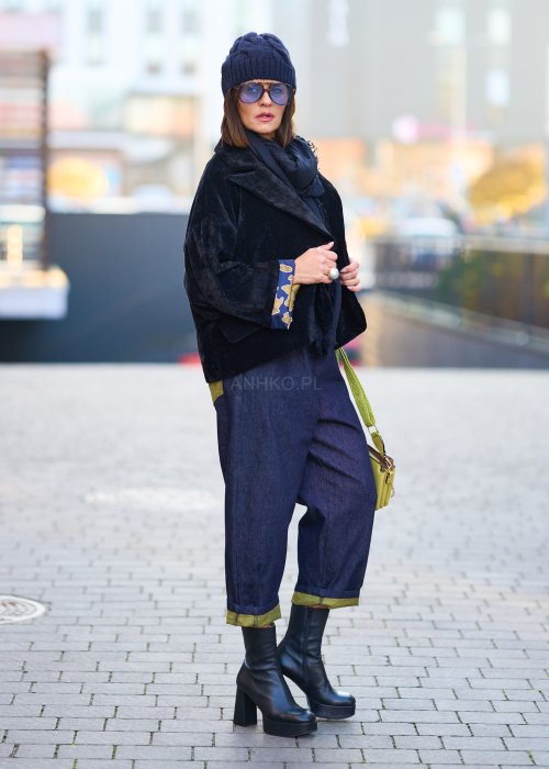 Luźne granatowe spodnie jeansowe z zielonymi detalami na kieszeni i podwiniętych nogawkach, stylizowane z dopasowaną bluzką i botkami na obcasie w miejskim looku.