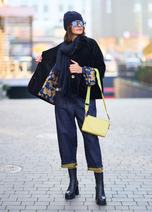 Luźne granatowe spodnie jeansowe z zielonymi detalami na kieszeni i podwiniętych nogawkach, stylizowane z dopasowaną bluzką i botkami na obcasie w miejskim looku.