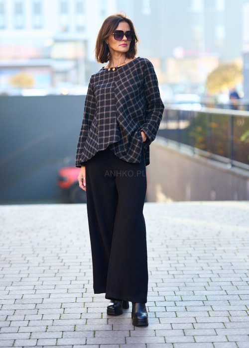 Czarne damskie spodnie z prostą, lekko rozszerzaną nogawką, gładkie, o klasycznym kroju, zestawione z czarnymi botkami na obcasie