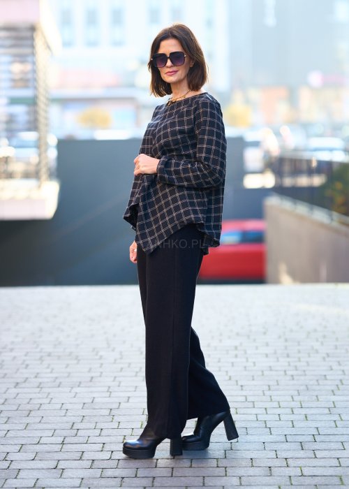 Czarne damskie spodnie z prostą, lekko rozszerzaną nogawką, gładkie, o klasycznym kroju, zestawione z czarnymi botkami na obcasie