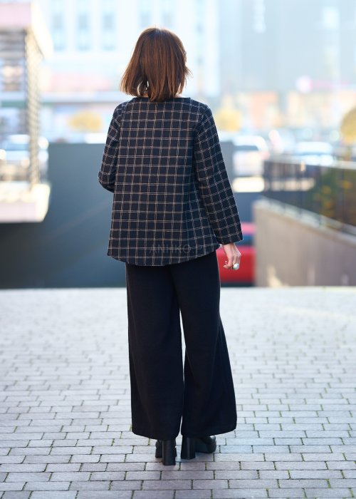 Czarne damskie spodnie z prostą, lekko rozszerzaną nogawką, gładkie, o klasycznym kroju, zestawione z czarnymi botkami na obcasie