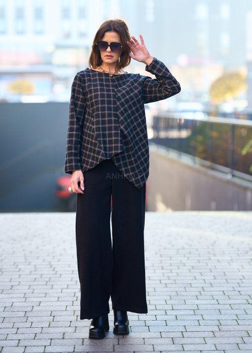 Czarne damskie spodnie z prostą, lekko rozszerzaną nogawką, gładkie, o klasycznym kroju, zestawione z czarnymi botkami na obcasie