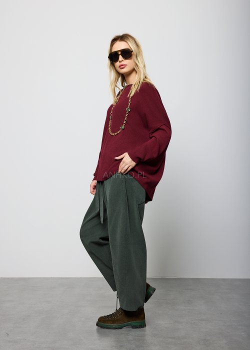 Ciemnozielone, luźne spodnie z miękkiej tkaniny z elastyczną talią i troczkiem, nogawki zwężane ku dołowi