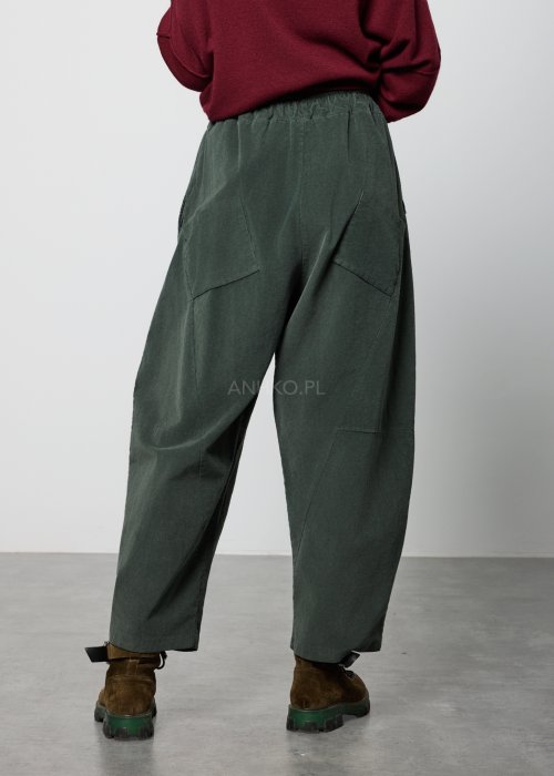 Ciemnozielone, luźne spodnie z miękkiej tkaniny z elastyczną talią i troczkiem, nogawki zwężane ku dołowi