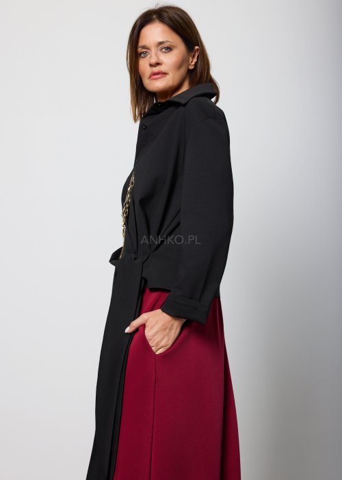 Czarna bluzka damska z asymetrycznym wiązaniem i klasycznym kołnierzem, o eleganckim fasonie. Stylizacja ze spódnicą w intensywnym kolorze w nowoczesnym wydaniu.