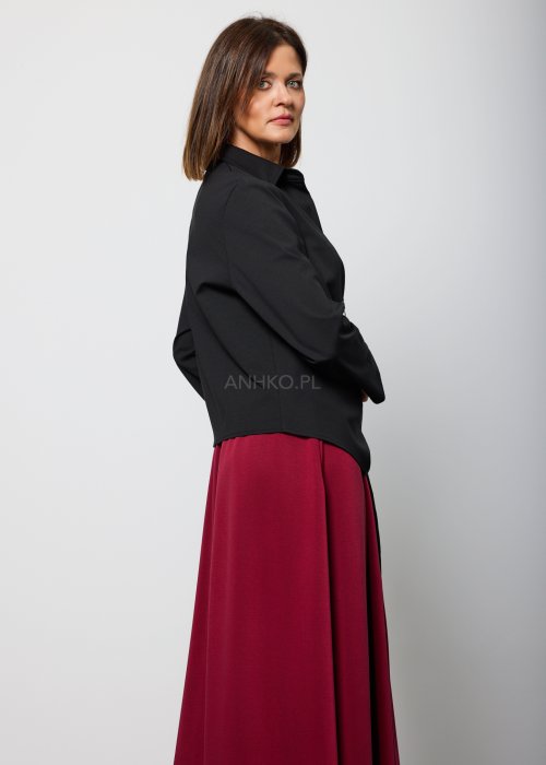 Czarna bluzka damska z asymetrycznym wiązaniem i klasycznym kołnierzem, o eleganckim fasonie. Stylizacja ze spódnicą w intensywnym kolorze w nowoczesnym wydaniu.