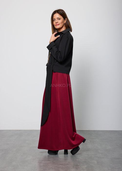 Czarna damska koszula z długim rękawem, wykonana z gładkiego, lejącego materiału, z kołnierzykiem i dekoltem w kształcie litery V; asymetryczny krój z wiązaniem po boku, styl elegancki i nowoczesny.