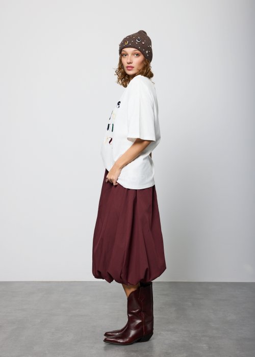 Bordowa damska spódnica midi o fasonie balonowym, z szerokim pasem w talii i marszczeniem u góry, wykonana z miękkiej, lejącej tkaniny; dół zaokrąglony z podwinięciem, styl nowoczesny i elegancki.