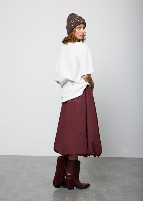 Bordowa damska spódnica midi o fasonie balonowym, z szerokim pasem w talii i marszczeniem u góry, wykonana z miękkiej, lejącej tkaniny; dół zaokrąglony z podwinięciem, styl nowoczesny i elegancki.