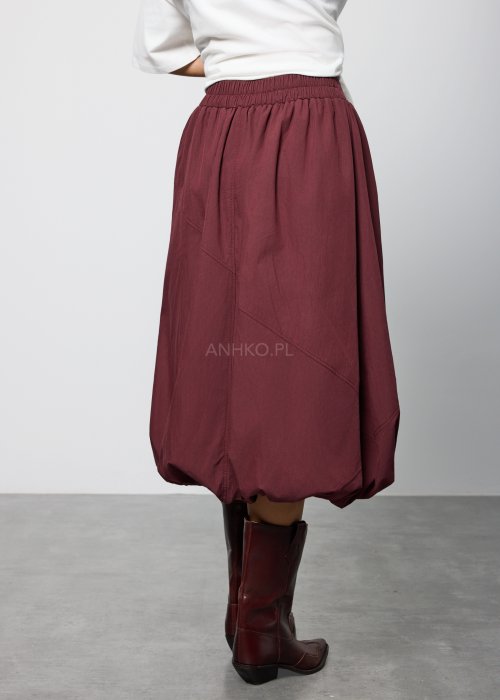 Bordowa damska spódnica midi o fasonie balonowym, z szerokim pasem w talii i marszczeniem u góry, wykonana z miękkiej, lejącej tkaniny; dół zaokrąglony z podwinięciem, styl nowoczesny i elegancki.