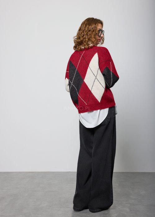 Czarne damskie jeansy z prostą, lekko rozszerzaną nogawką, klasyczny krój z pięcioma kieszeniami i zapięciem na guzik, noszone z białymi sneakersami.