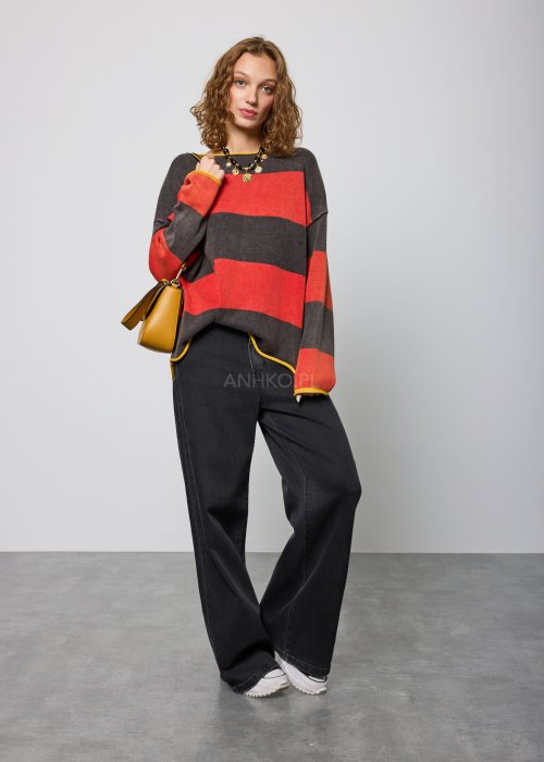 Czarne damskie jeansy z prostą, lekko rozszerzaną nogawką, klasyczny krój z pięcioma kieszeniami i zapięciem na guzik, noszone z białymi sneakersami.