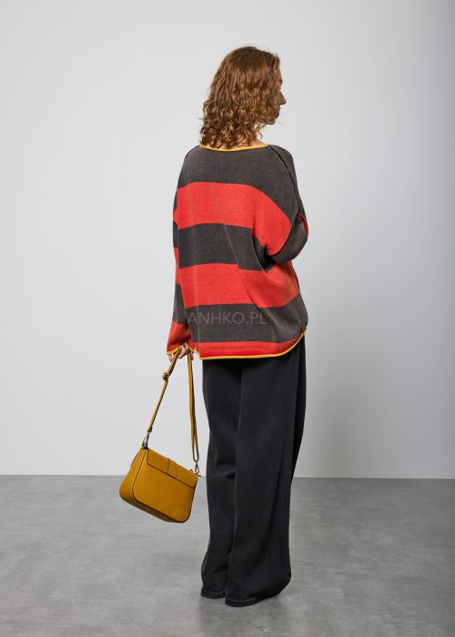 Czarne damskie jeansy z prostą, lekko rozszerzaną nogawką, klasyczny krój z pięcioma kieszeniami i zapięciem na guzik, noszone z białymi sneakersami.