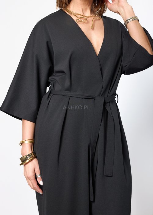 Czarny damski kombinezon o eleganckim, minimalistycznym kroju. Model z głębokim dekoltem w kształcie litery V, rękawami 3/4 i paskiem do wiązania w talii